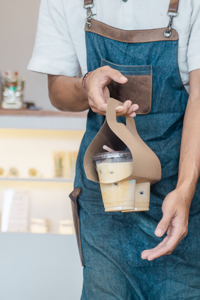 ROU barista carrying takeaway coffee.